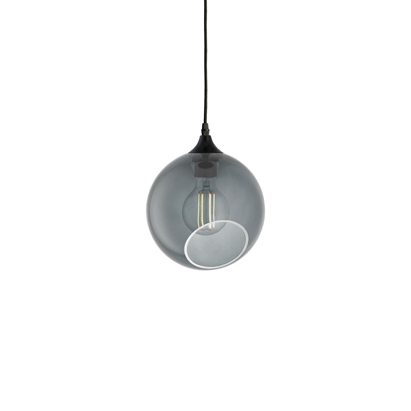 Rund pendel lampe i smoked glas med et afskåret stykke med kig til pæren. Fatning er sort og ledningen er af sort stof.