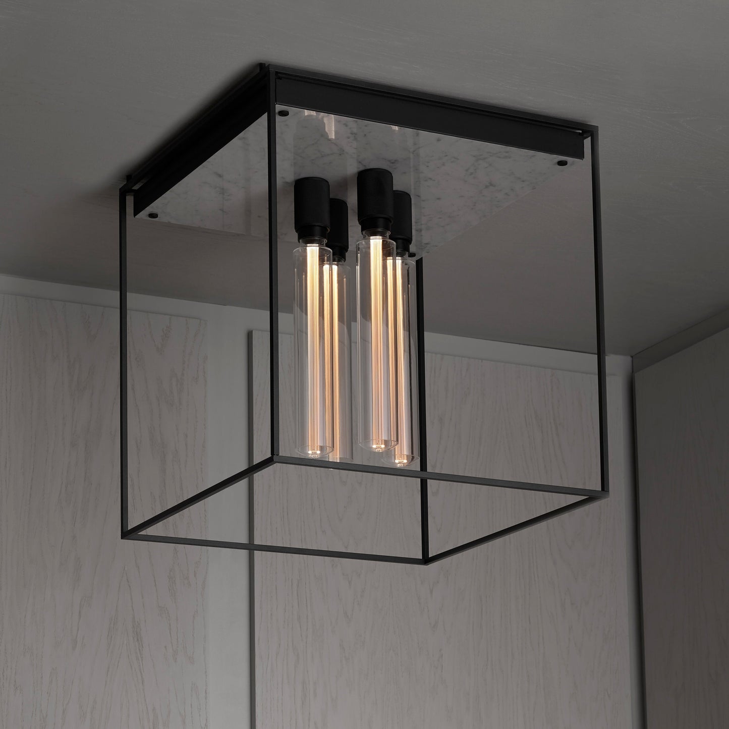 Caged loftlampe fra Buster and Punch i sort med hvid marmor bagplade.