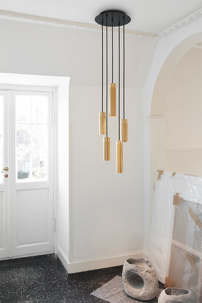 Lys entre med en loftlampe med fem pendler i massiv messing med diamant slebet mønster, sorte stofledninger og behageligt afdæmpet lys