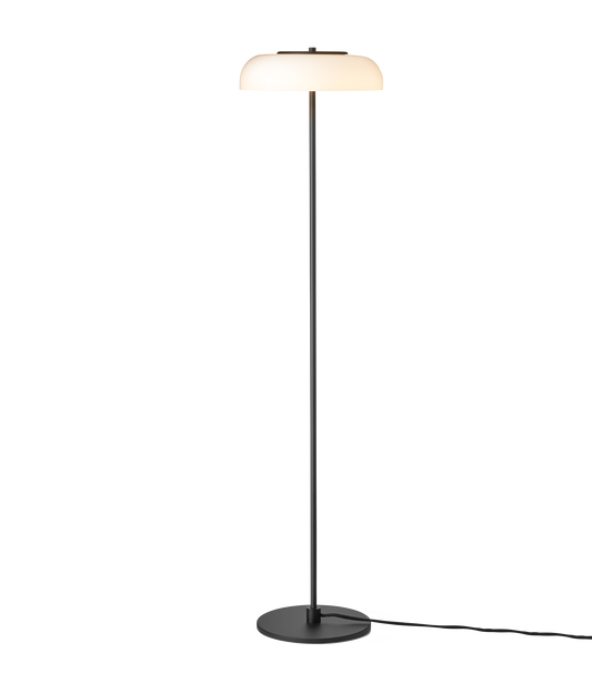 Gulvlampe med sort stel og fatning samt glasskærm i opalglas, på hvid baggrund