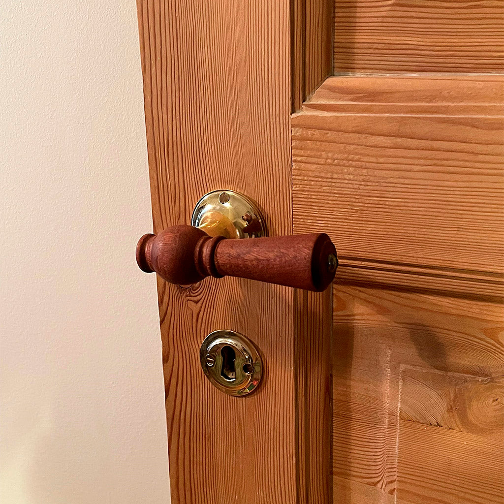 Trædørhåndtag med messing detaljer.